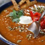 Spoon dipping into a bowl of Sweet Potato and Chorizo Soup.