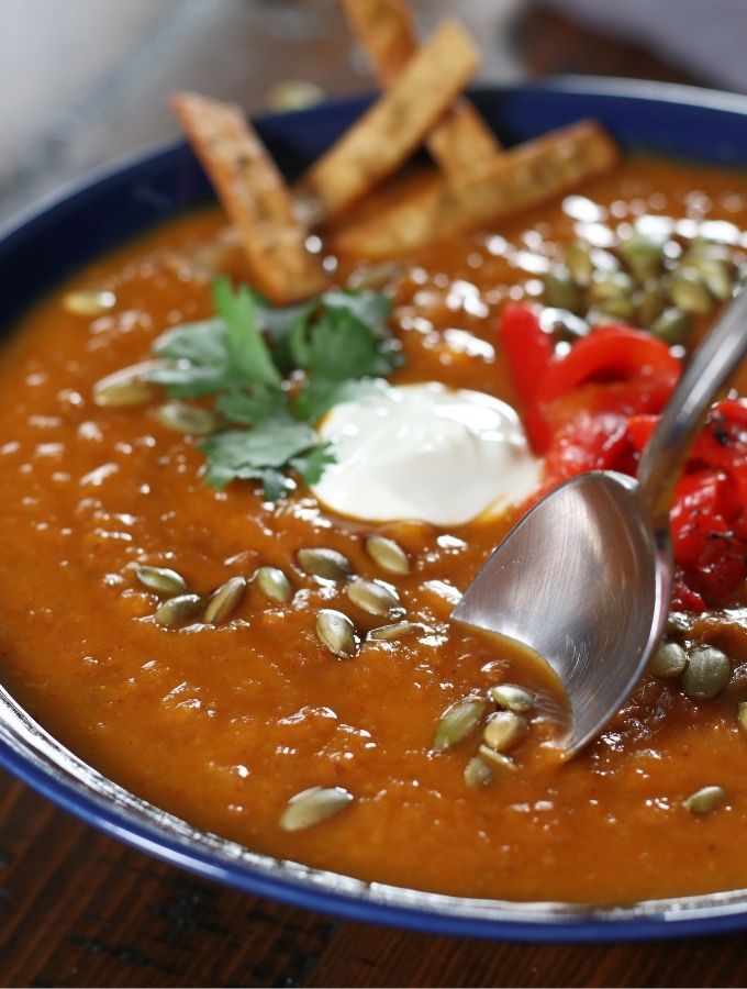 Spoon dipping into a bowl of Sweet Potato and Chorizo Soup.
