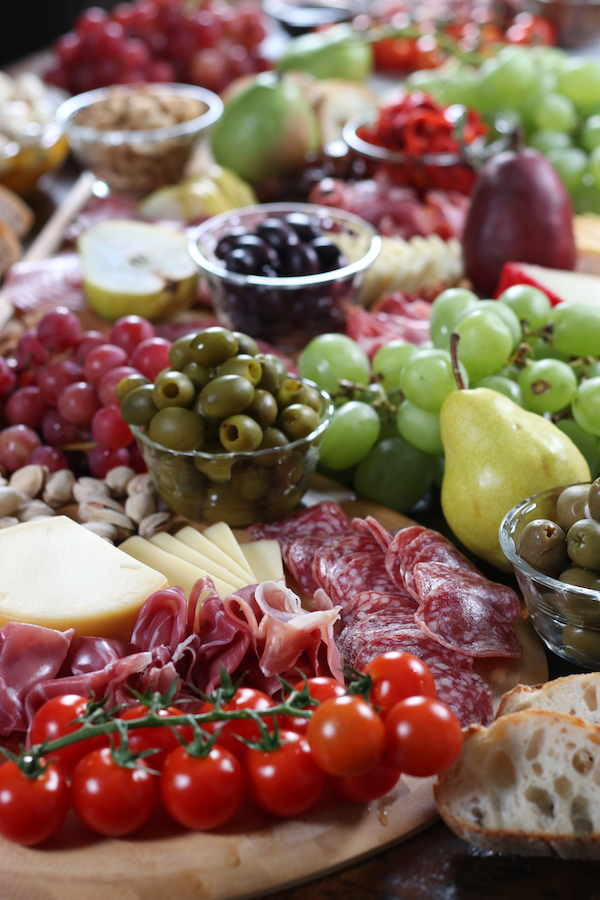 Charcuterie Board with cherries on the vine and Italian meats.