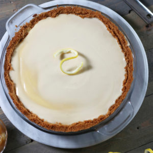 A whole Cream Cheese Pie sitting on a wooden table.