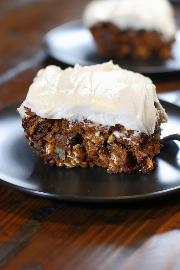 Two slices of Ooey Gooey Pumpkin Cake sitting on a brown table.