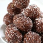 Up close photo of Rum Balls sitting on a white plate.