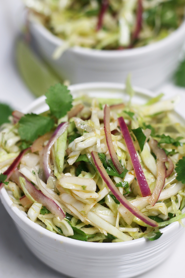 Two single servings of Mexican Cabbage Slaw in small white bowls.