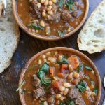 Overhead photo of two bowls of White Bean Stew with slices of bread.