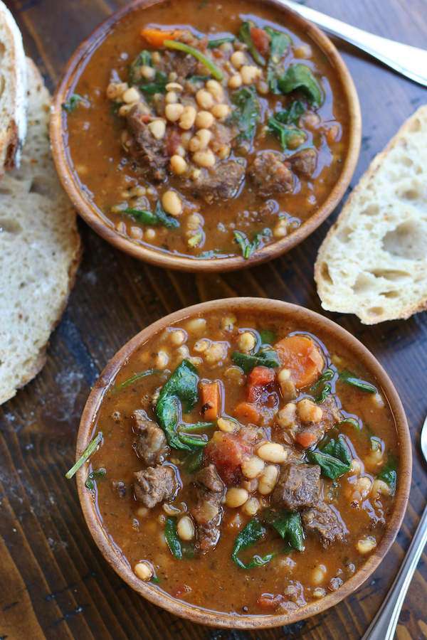 Overhead photo of two bowls of White Bean Stew with slices of bread.