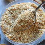 Spoonful of DIY Breadcrumbs being taken out of a bowl.