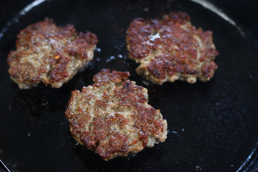 Pork Breakfast Sausage frying in a cast iron skillet.