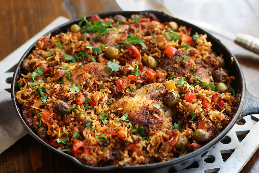 A cast iron frying pan full of Chicken and Chorizo bake sitting on a trivet.