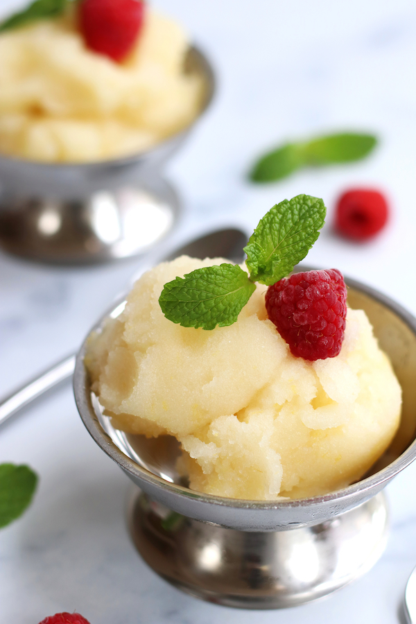 Two servings of Homemade Lemon Sorbet served in stainless steel parfait cups.