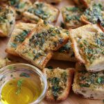 Slices of Garlic Bread From Scratch sitting on a cutting board.