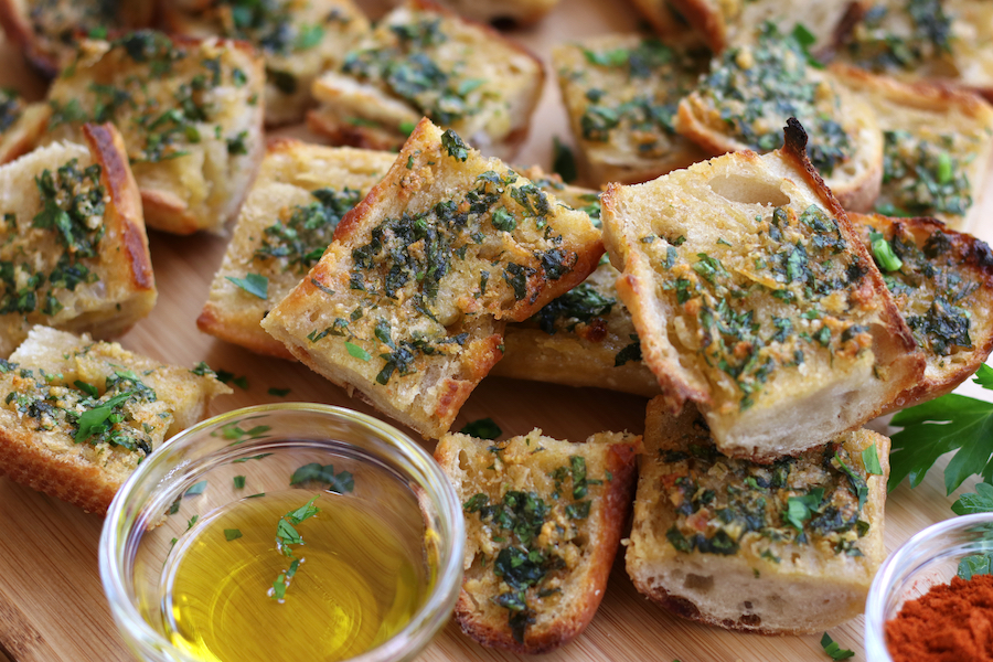 Slices of Garlic Bread From Scratch sitting on a cutting board.