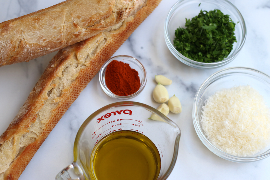 Ingredients for Sourdough Garlic Bread laying on a marble countertop.