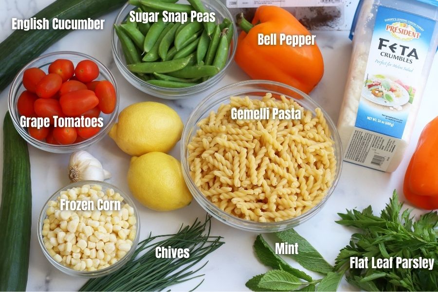 Ingredients for Summer Pasta Salad laid out on a white countertop.