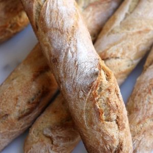 Sourdough Baguettes sitting on a white counter.