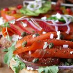 Lox Bagel with heirloom tomato slices, capers and arugula.