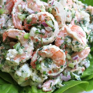 Shrimp Salad Recipe on a white plate sitting next to a fork.