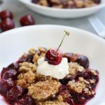 Cherry Crisp topped with a dollop of whipped cream and a fresh cherry.