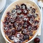 Over head photo of Cherry Clafoutis in a white baking pan with handles.
