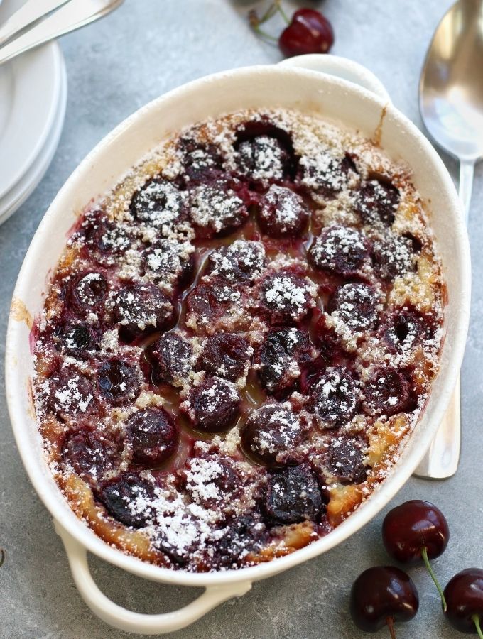 Over head photo of Cherry Clafoutis in a white baking pan with handles.