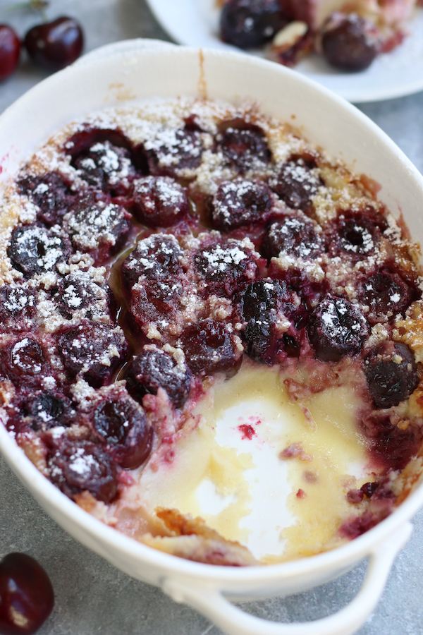 Clafoutis Cherry Recipe in a baking pan with a serving removed.