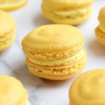 Up close photo of Lemon Macarons on a white countertop.