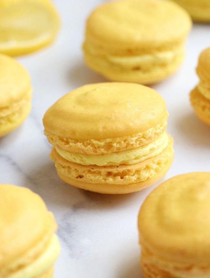 Up close photo of Lemon Macarons on a white countertop.