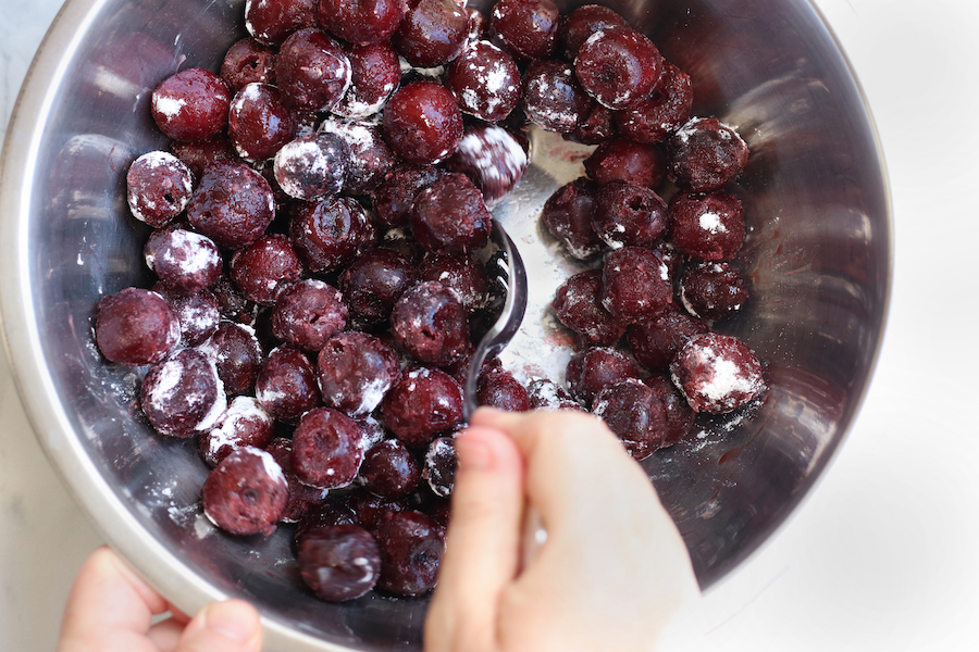 Mixing cherries to coat with cornstarch.