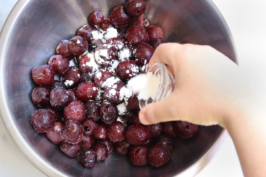 Sprinkling frozen cherries with cornstarch.
