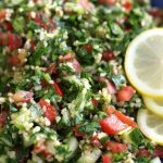 A bowl of Tabouli Salad garnished with fresh lemon slices.