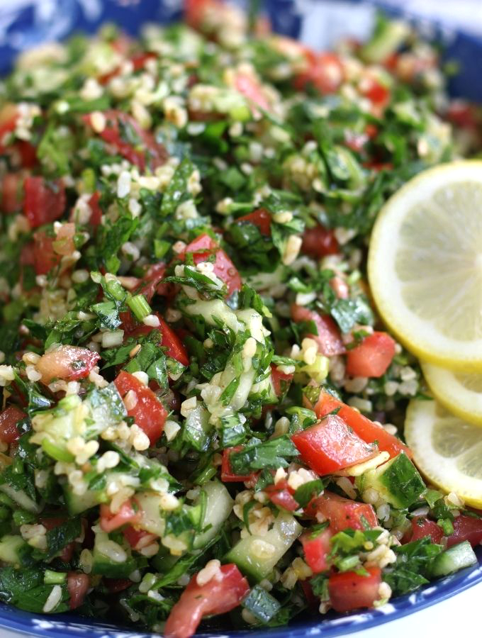 A bowl of Tabouli Salad garnished with fresh lemon slices.