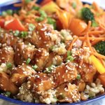 Up close photo of Terriaki Chicken Bowl with brown rice, broccoli, bell peppers and matchstick carrots.