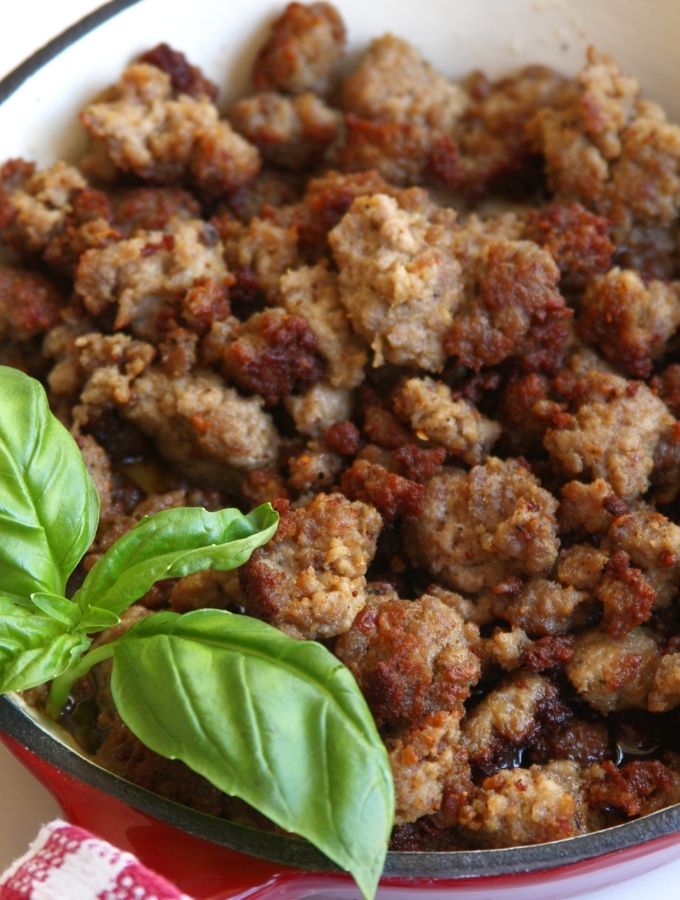 Cooked Homemade Italian Sausage garnished with fresh basil leaves.