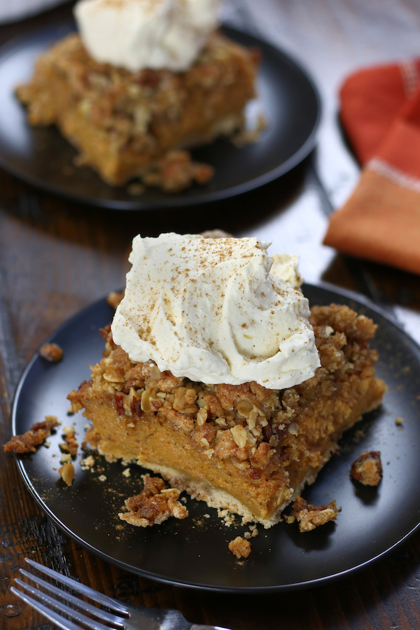 Two servings of Pumpkin Pie Crisp on two black plates.