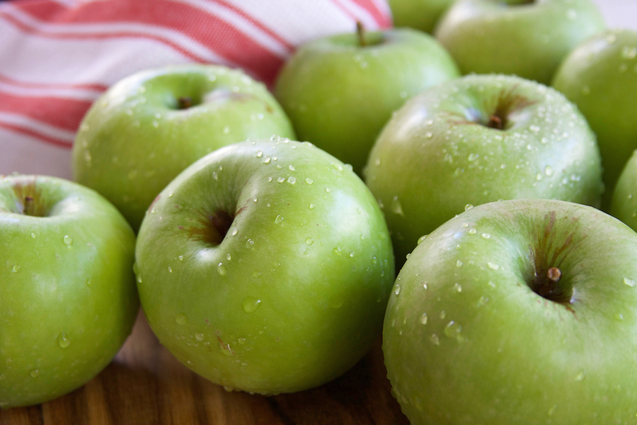 Granny Smith Apples for Apple Crisp sitting on a table with water droplets.