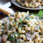 Two servings of Garlic Mushroom Pasta on brown plates.