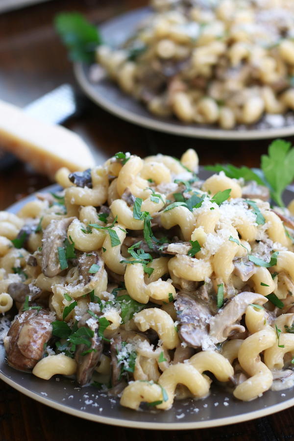 Two servings of Garlic Mushroom Pasta on brown plates.