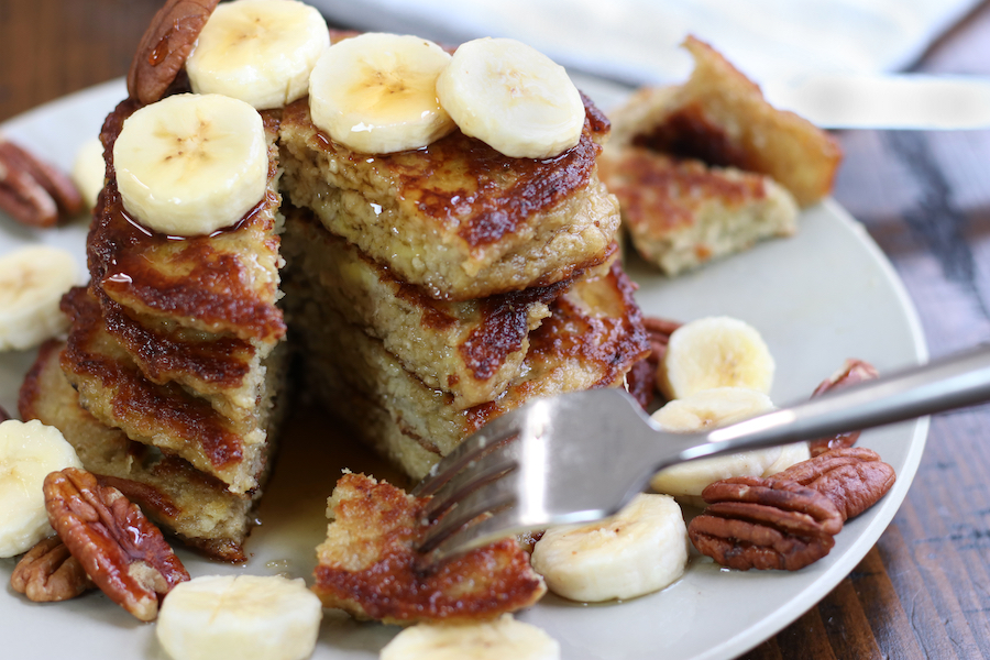 A stack of Healthy Banana Pancakes that have been sliced into.