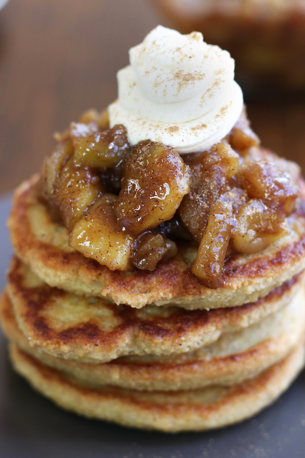 Apple Compote for Pancakes recipe on top of a stack of pancakes topped with whipped cream.