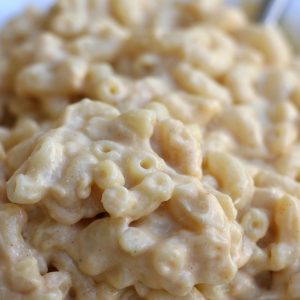 A serving of creamy Mac and Cheese in a white bowl.