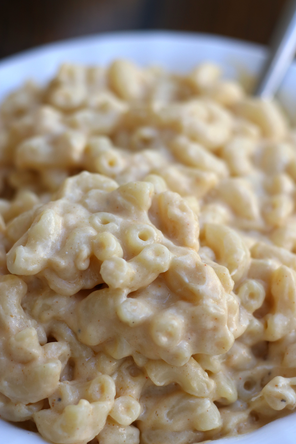 A serving of creamy Mac and Cheese in a white bowl.