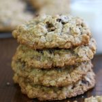 A stack of Oatmeal Raisin Coconut Cookies on a wooden table.