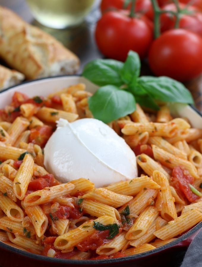 Tomato and Burrata Penne Pasta in an enameled cast iron frying pan.