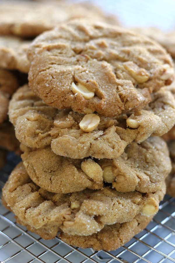 4 Peanut Butter Cookies Stacked together on a wire cooling rack.