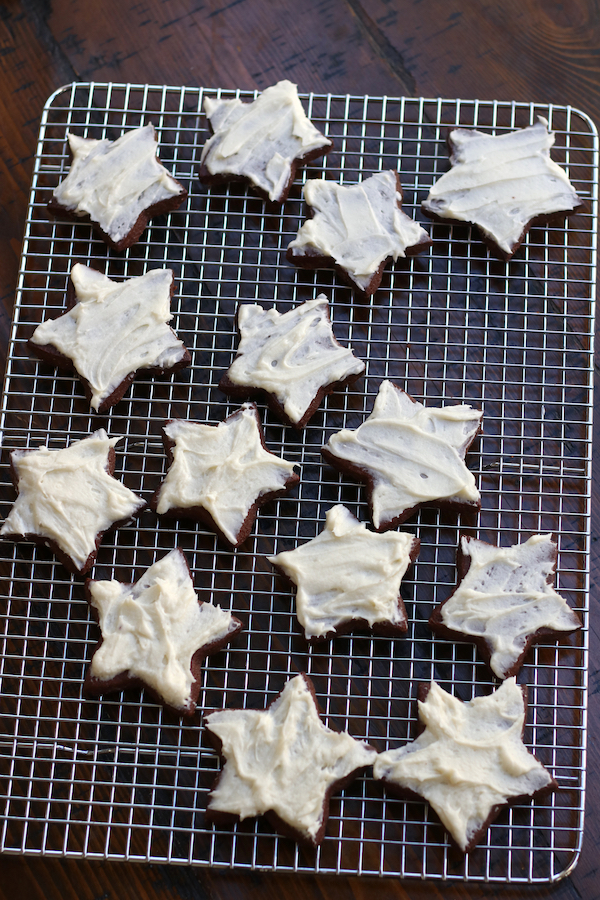 Frosted star shaped Chocolate Christmas Cookies on a wire rack.