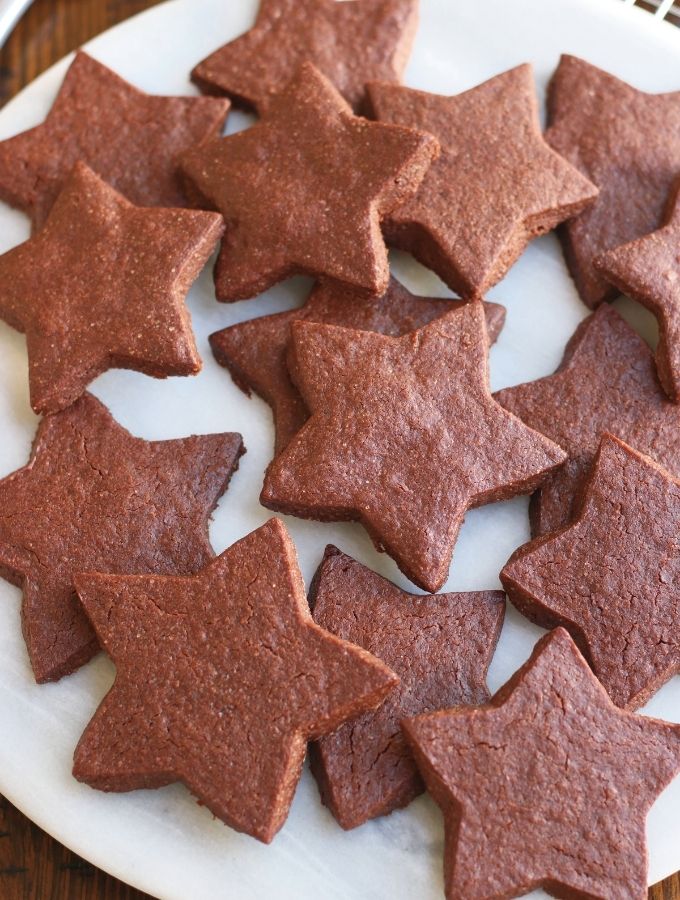 Star shaped Chocolate Sugar Cookies on a white platter.
