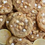 Overhead photo of Lemon and White Chocolate Cookies on a platter with lemon halves.