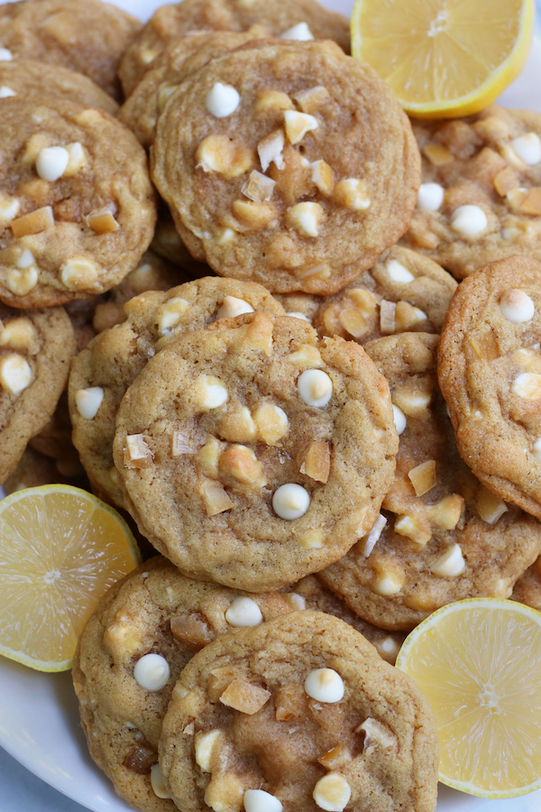 Overhead photo of Lemon and White Chocolate Cookies on a platter with lemon halves.