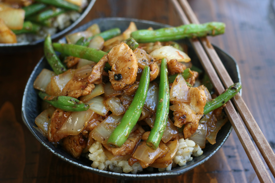 Chicken and Green Bean Stir Fry served in a grey bowl with chopsticks.