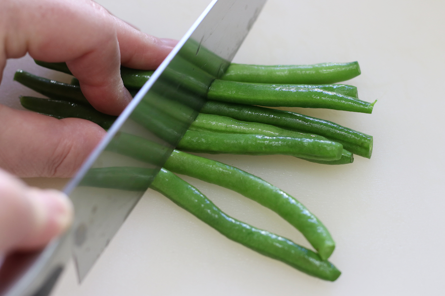 Cutting green beans into bite sized pieces for Green Bean Stir Fry.