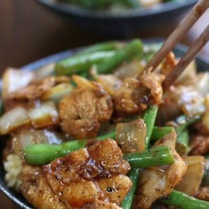 Green Bean Stir Fry being eaten with chopsticks.